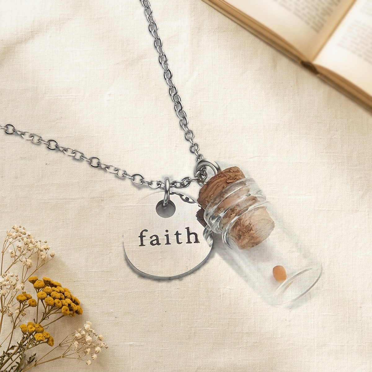 Mustard Seed Faith Necklace on cream linen: a corked glass vial holding one mustard seed beside a round faith charm